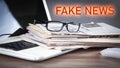 Fake News. Newspapers, eyeglasses, laptop computer