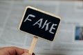 Fake news. Sign with the inscription fake on the background of newspapers Royalty Free Stock Photo