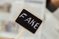 Fake news. Sign with the inscription fake on the background of newspapers Royalty Free Stock Photo