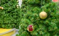 The fake pine decorated with red gift box and golden ribbon and pink Teddy bear in a golden ball on green leaves background Royalty Free Stock Photo