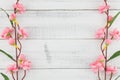 Fake pink flower branches on white wood background
