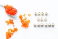 Fake red caviar eggs on white surface next to fake red caviar lettering. The concept of selling counterfeit food and cheating the Royalty Free Stock Photo