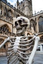 A fake skeleton posed outside of Bath Cathedral