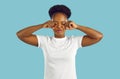 Funny capricious young african american woman pretending to cry against light blue background. Royalty Free Stock Photo