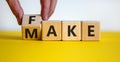 Fake it until you make it symbol. Businessman turns a cube and changes the word `fake` to `make`. Beautiful white and yellow Royalty Free Stock Photo