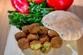 Falafel balls,sweet red pepper ,pita-arabian bread and green fresh parsley on wood rustic background.