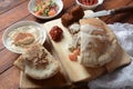 Falafel in pita bread with vegetable salad, harissa sauce, humus, tahini on wooden background.