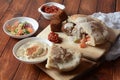 Falafel in pita bread with vegetable salad, harissa sauce, humus, tahini on wooden background.