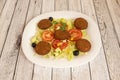 falafel plate with salad of lettuce, tomato, white onion, sweet corn, iceberg lettuce and black olives with cucumber served in a Royalty Free Stock Photo