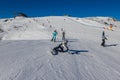 Ski slope with skier under blue sky. People drive down the snowy mountains on skis. Group of