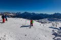 Ski slope with skier under blue sky. People drive down the snowy mountains on skis. Group of