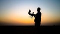 Falcon trainer silhouette in desert with sunset scenery, Dubai, UAE