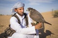 Falconer with a falcon in a desert near Dubai