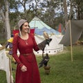 Falconer in medieval costume with a kestrel on her arm.