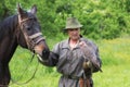 Falconer in traditional clothing with peregrine falcon and horse