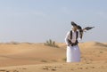 Falconer is training Harrier Hawk in a desert near Dubai