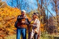 Fall activities. Senior family couple walking in autumn park. Man and woman enjoying nature outdoors talking Royalty Free Stock Photo