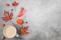 Fall or autumn composition. Coffee cup, autumn leaves, flowers, berries, nuts on concrete background