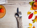 Fall or autumn themed place setting with a knife, spoon and fork, burlap napkin, colorful leaves, copy space for text Royalty Free Stock Photo