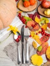 Fall or autumn themed place setting with a knife, spoon and fork, burlap napkin, colorful leaves, physalis, pumpkin, apples, copy Royalty Free Stock Photo