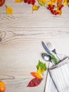 Fall or autumn themed place setting with a knife, spoon and fork, napkin on a plate on an arrangement of colorful leaves, copy Royalty Free Stock Photo