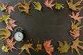 Fall Back, Daylight Saving Time. Black clock and autumn leaves frame Royalty Free Stock Photo