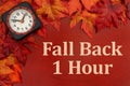 Fall Back 1 hour with clock and fall leaves for time change Royalty Free Stock Photo