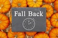 Fall Back 1 hour time change message on a chalkboard sign on pumpkins Royalty Free Stock Photo