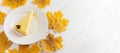 Fall banner with pumpkin pie piece on white plate and yellow maple leaves on white wooden table. Royalty Free Stock Photo