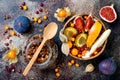 Fall breakfast bowl with chocolate granola, coconut yogurt and autumn seasonal fruits and berries. Healthy vegetarian breakfast