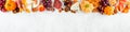 Fall charcuterie top border against a white marble banner background Royalty Free Stock Photo