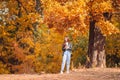 Fall concept - beautiful woman in autumn park under fall foliage Royalty Free Stock Photo