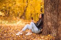 Fall concept - beautiful woman in autumn park under fall foliage Royalty Free Stock Photo