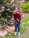 Young girl`s spontaneous, joyful play with rose-pink flower petals. Royalty Free Stock Photo