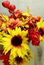 Fall flower arrangement of sunflowers, small red flowers, red berries, peach red flowers