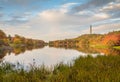 Fall foliage surrounds Lake Marcia as High Point Veteran`s Monument stands atop the mountain at sunset