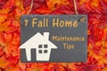 Fall Home Maintenance Tips with a chalkboard with a wood house Royalty Free Stock Photo