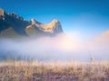 Fall landscape. Foggy landscape in the morning. Mountain peak. Sunbeams in a valley. Field in a mountain valley at dawn.