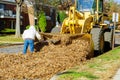 During the fall when leaves are falling near houses over the entire city, bulldozer trucks are used by workers from many