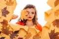 Fall look. Makeup girl peek through torn paper. Pretty girl cover face with autumn leaf. Young woman look out of hole Royalty Free Stock Photo
