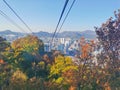 Fall maple leaves foliage Autumn with city apartments scene and cable car tower in Seoul, South Korea Royalty Free Stock Photo