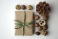 Fall mood. Acorns, tree nuts and seeds with a pine cone and a gift-wrapped box in brown paper and raffia with copy space.