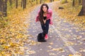 Fall, pets and people concept - woman and black cat are walking in autumn park
