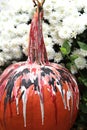 Fall pumpkin decorated for Halloween near mums Royalty Free Stock Photo