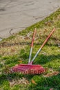 Fall scene - two leaf rakes lying on the ground with a few brown oak leaves left from cleaning up - selective focus Royalty Free Stock Photo