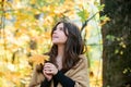 Fall season mood. Autumn beauty. Woman fashion model with fall maple leaf outdoors.