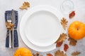 Fall season table setting with pumpkins, leaves and cutlery Royalty Free Stock Photo