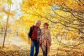 Fall season walk. Senior couple walking in autumn park. Man and woman spending time together outdoors Royalty Free Stock Photo