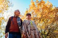 Fall season walk. Senior family couple walking in autumn park. Man and woman spending time together outdoors Royalty Free Stock Photo