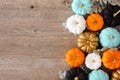 Fall side border of colorful pumpkins and silvery leaves against a wood background